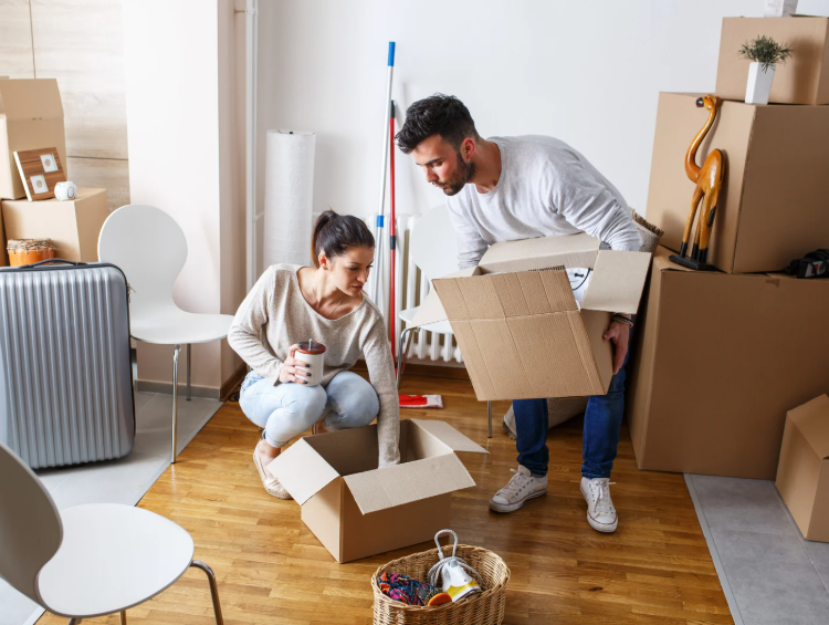 a man and a woman are packing up their home to prepare for a move